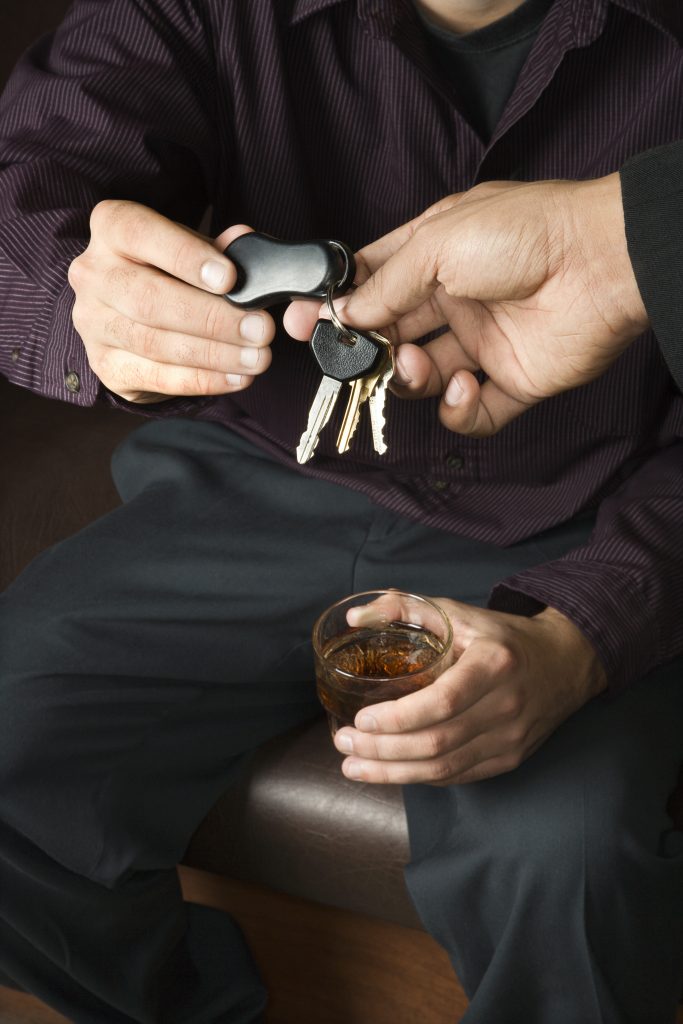man-with-drink-handing-over-car-keys-1951137-683x1024